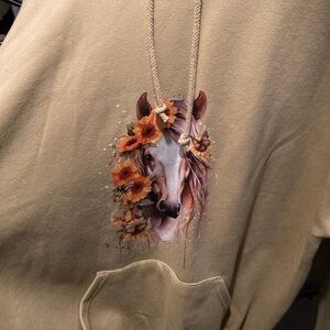A beige hoodie with a horse